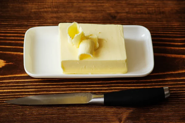 Stück Butter auf einem Holztisch — Stockfoto
