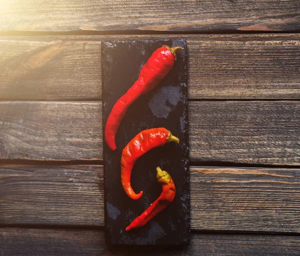Pimienta roja en un plato negro — Foto de Stock