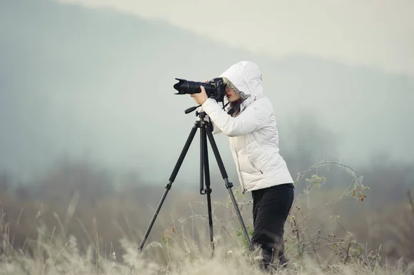 Fotógrafo con cámara y trípode al aire libre tomando foto paisaje —  Fotos de Stock