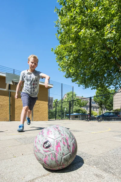 Chico Corriendo Una Pelota Campo Fútbol Callejero Con Intención Golpearlo Imágenes de stock libres de derechos