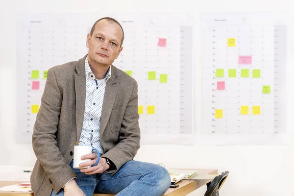 Geschäftsmann Brauner Jacke Und Kaffeetasse Sitzt Auf Einem Konferenztisch Vor — Stockfoto