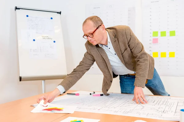 Arquitecto Masculino Inteligente Que Busca Documentos Mientras Trabaja Plano Oficina —  Fotos de Stock