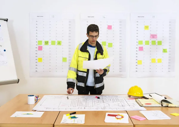作業者は 付箋と背景に Flipover Planboard を使用してオフィスで図面をチェックテクニカル — ストック写真