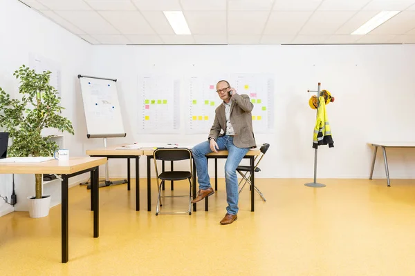 Managing Partner Zittend Het Planbureau Met Een Whiteboard Planning Sheets Rechtenvrije Stockafbeeldingen