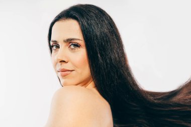 Stüdyoda poz veren taze tenli ve uzun saçlı güzel esmer kadın model. 