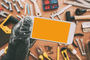 Tamirci akıllı telefon app ile boş perde. Telefon elinde tutan el ulağı. Bakım iş cep telefonu uygulaması veya iş hizmet, en iyi görünüm için alanı Kopyala