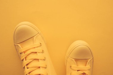 Spor ayakkabı ayakkabı gençlik yaşam tarzı konsepti için pastel tonda sarı ayakkabı ile kopya alanı, üstten görünüm