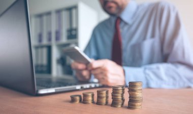 Madeni para stacker, muhasebe, bütçe ve vergi hesaplamalarını yaparken Office yığılmış para ile işadamı