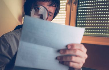 Lawyer reading document agreement disclaimer with magnifying glass in dark law office interior, selective focus clipart