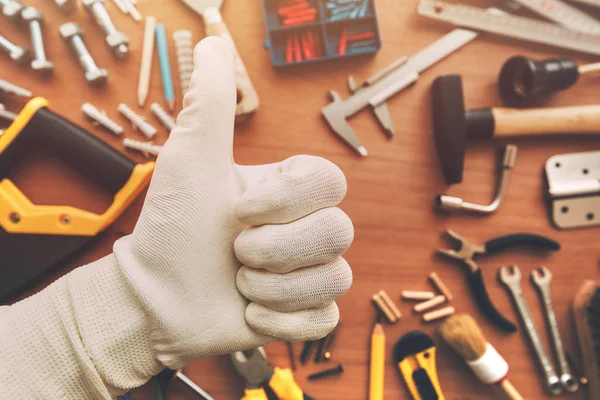 DIY araçları, en iyi görünümü ile çalışma masası üzerinde bakım el işleri ustası'nın onayı el işareti yukarı başparmak