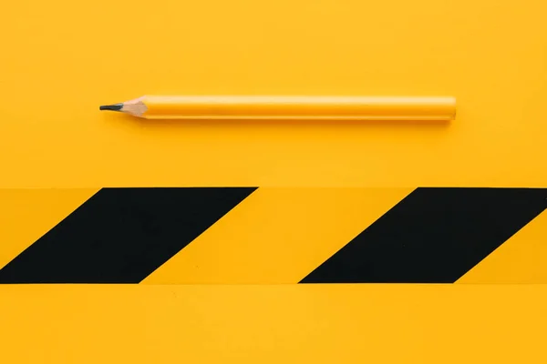 Classic yellow carpenter handyman pencil for on-site marking on same color background as copy space, minimalistic composition