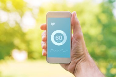 App için smartphone, sahte ekran yukarı ölçme kalp atışı. Nabız kontrol sahte uygulama ekranı ile cep telefonu tutan adam