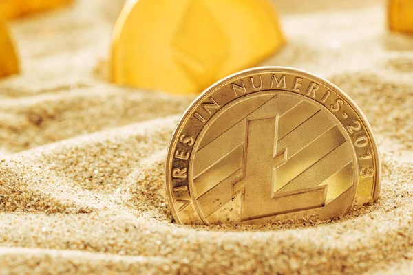 Silver Litecoin coin in sand, conceptual image for lost and found valuable cryptocurrency coins that are standing the test of time.