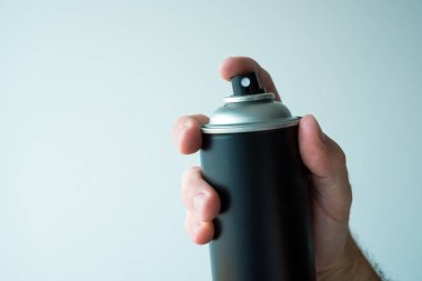 Yaklaşık boş duvara sokak bazı sanat eseri yaratmak için renk sprey can tutan grafiti sanatçısı