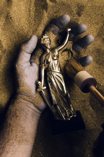 法医专家发现尸体被埋葬在沙漠沙子里 手里拿着正义雕像 冷案犯罪现场警察调查的概念性形象 — 图库照片
