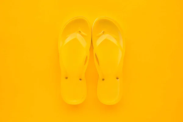 与复制空间相同的颜色背景下的黄色翻转触发器对的顶部视图 沙滩凉鞋或拖鞋在简约温暖的夏天色调的成分 — 图库照片
