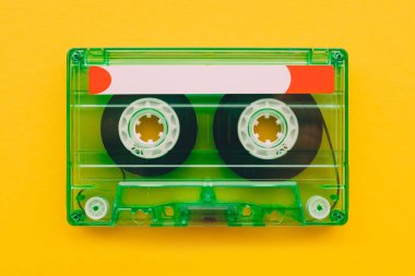 Audio cassette tape on yellow background with copy space, feeling nostalgia for retro vintage technology clipart