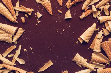 Ezilmiş dondurma waffle koni üzerinde koyu kahverengi zemin, düz yatıyordu