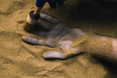 Adli tıp uzmanı çöl kuma gömülü ceset keşfetmek. Bir soğuk durumda cinayet suç mahalli polis soruşturma için kavramsal görüntü.