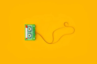 Parlak sarı arkaplanlı karışık bantlı ses kasetinin üst görünümü kopya alanı, minimal kompozisyon