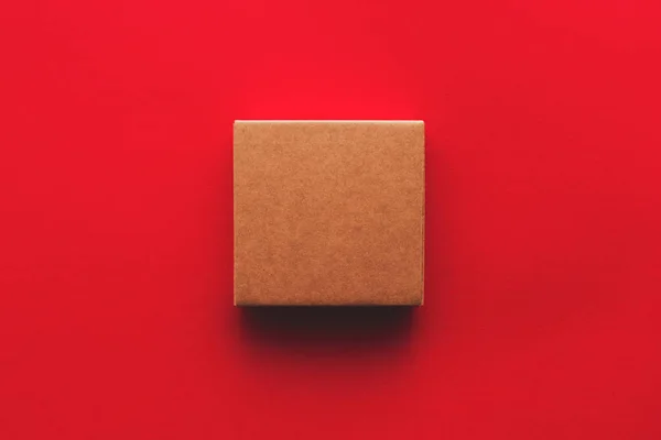 赤の背景に段ボール箱パッケージのトップ ビュー — ストック写真