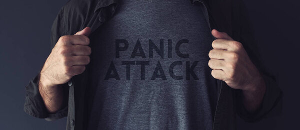 Panic attack concept, guy stretching shirt to reveal the title imprint on his chest