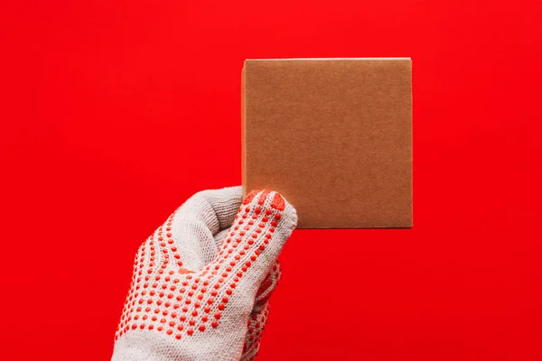 Worker Protective Gloves Holding Cardboard Product Package Isolated Red Background — Stock Photo, Image