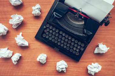 Writer's block concept with typewriter and crumpled paper on work desk clipart