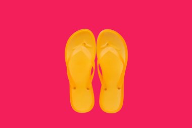 Neon pembe arka plan, kopya alanı ile üstten görünüm üzerinde sarı beach flip flop