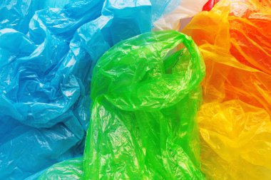 Renkli plastik torbalar, tüketim ve çevre kirliliği kavramı yığını