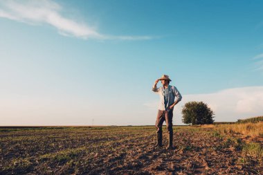 Düşünme ve sonraki tarımsal etkinlik planlama zemin, çıplak boş alan toprak üzerinde duran erkek çiftçi portresi