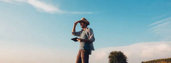 農業生産の計画および準備の近代的な技術を使用して日没 深刻な自信を持って男性の裸の空のフィールドにタブレット コンピューターと農家農業 — ストック写真