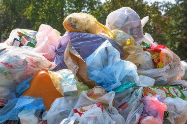 NOVI SAD, SERBIA - AUGUST 18, 2018: Municipal solid waste or communal garbage is overflowing containers in Novi Sad during weekends, illustrative editorial clipart