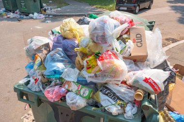 NOVI SAD, SERBIA - AUGUST 18, 2018: Municipal solid waste or communal garbage is overflowing containers in Novi Sad during weekends, illustrative editorial clipart
