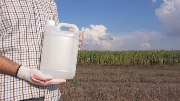 农夫在玉米地里持有农药化学水罐 空白无标号瓶作为模拟的复制空间的除草剂 杀菌剂或杀虫剂用于玉米作物耕作 — 图库视频影像