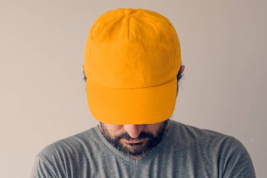 Mockup metin ya da grafik tasarımı için sarı beyzbol şapkası giyen adam