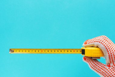 Boyutu şerit metre ile ölçme tamirci El aracıyla üzerinde mavi arka plan izole