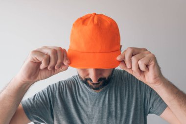 Mockup metin ya da grafik tasarımı için turuncu beyzbol şapkası giyen adam