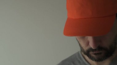 Turuncu beyzbol şapkası adam onun göz ve yüz gizleme