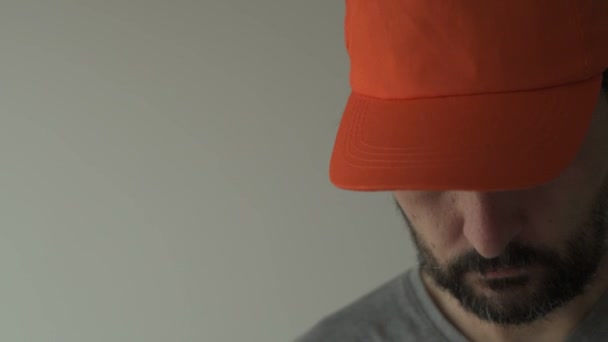 Man Wearing Orange Baseball Cap Hiding His Eyes Face — Stock Video