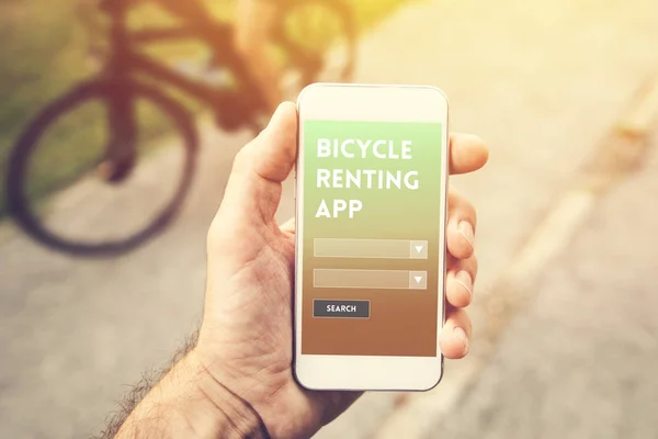 Bicycle renting app for mobile devices, male hand holding smartphone with mock up screen