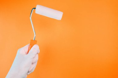 El ile canlı sıcak renkler bir duvar boyama boya silindiri