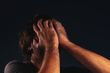 Adam umutsuzluk içinde yüz, düşük anahtar portre kapsayan eller ağlıyor