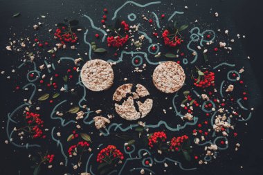 Düz yatıyordu gevrek pirinç kek çiçek aranjman arka plan, havai görünümü üst koyu ahşap zemin üzerine