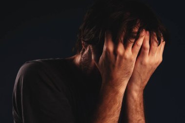Adam umutsuzluk içinde yüz, düşük anahtar portre kapsayan eller ağlıyor