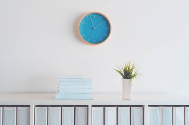 Modern iş ofis iç detay heykelde duvar saati ve raf kitaplar, bitki ve yüzük bağlayıcı dosya