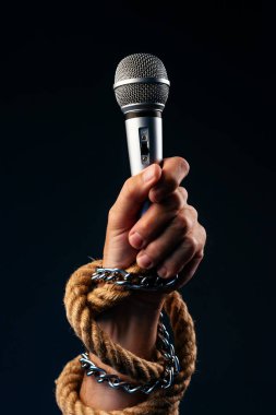 Gazetecilik, Erkek elinde mikrofon ile kavramsal görüntü ve basın özgürlüğü bağlı zincirleri ve halatlar, düşük anahtar görüntü ile