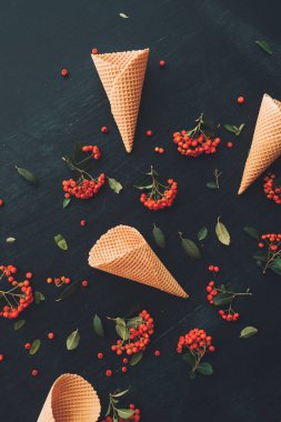 Gözleme dondurma külahı düz ahşap arka plan vahşi berry meyve düzenleme ile dekore edilmiş üstten görünüm koyu siyah üzerinde yatıyordu