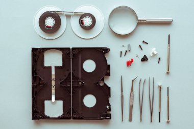 Düz vhs video kaset parçaları pastel mavi arka plan, üstten görünüm retro teknoloji ve medya kavramı üzerinde yatıyordu.