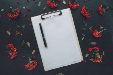 Düz Pano Not defteri boş mockup kağıt yukarıdan izlendi vahşi berry meyve düzenleme ile dekore edilmiş koyu arka plan üzerinde yatıyordu
